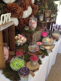 a table topped with lots of different types of candies and desserts on top of wooden crates