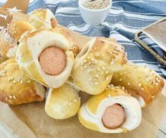 bread rolls with sausages and sesame seeds in them