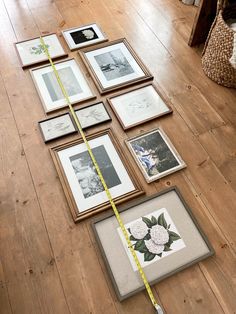 there are many framed pictures on the floor with a measuring tape in front of them