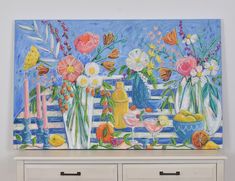 a painting on a wall with flowers and fruit in vases next to a dresser