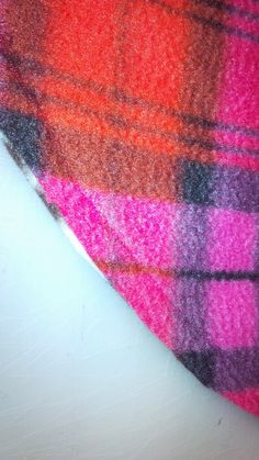 a pink and orange plaid tie laying on top of a white table