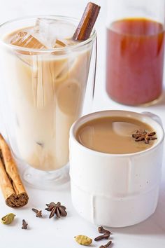 there is a cup of coffee with cinnamon and anise on the table next to it