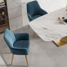 two green velvet chairs sitting next to a white marble table