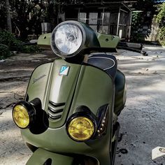 a green scooter parked in front of a building