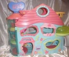 a pink and blue toy house with lots of toys in it