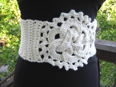 a white crocheted belt on top of a black mannequins torso