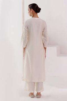 Ivory kurta features patra work and dori embroidery over its neckline and base. Paired with shantoon palazzo and an embroidered silk organza dupatta.
Components: 3
Pattern: Embroiderd
Type Of Work: Patra,Dori Work
Neckline: Keyhole
Sleeve Type: Long
Fabric: Chanderi, Silk Organza and Shantoon 
Color: Ivory
Other Details: 
Tassel dupatta
Model Height: 5ft 8 inches, wearing size S
Occasion: Puja - Aza Fashions Elegant Cotton Salwar Kameez With Cutwork, Elegant Cotton Kurta For Wedding, Elegant White Traditional Wear With Cutwork, Cream Cotton Elegant Salwar Kameez, Cream Cotton Palazzo Set For Wedding, Elegant Cream Cotton Salwar Kameez, Elegant Cotton Kurta With Cutdana, Elegant Cotton Palazzo Set With Cutdana, Elegant Cream Cotton Palazzo Set