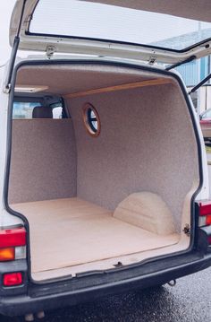 the back end of a white van with its trunk open and mattress in it's cargo compartment