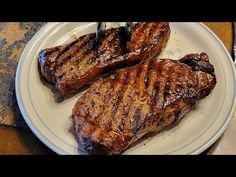 two steaks on a plate with a fork