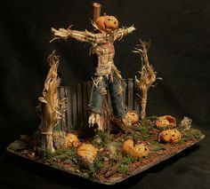 a scarecrow with pumpkins and corn stalks