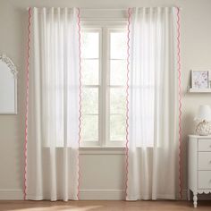 white curtains with pink scalloped trim in front of a windowsill and dresser