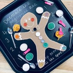 a child's handmade gingerbread man on a tray with spoons and measuring cups