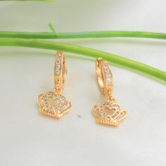 "♡ Dangle in regal delight with our Crown Earrings, a masterpiece of elegance and charm. Embrace timeless sophistication and radiate confidence with every sway. The crown symbol jewel represents glory, power, immortality, royalty and sovereignty. ♡ 14K Gold Plating ♡ Suitable for daily wear ♡ Light weight ♡ Hypoallergenic ♡ Nickel free ♡ Waterproof ♡ Tarnish Resistant ♡ Perfect gift for: Wife, Girlfriend, Sister, Daughter, Mom, Bridesmaid, and Friends. ♡ On events like: Graduation, Birthday, Mot Gold Crown Design Earrings As Gift, Gold Crown Design Earrings For Gift, Gold Dangle Hoop Earrings For Mother's Day, Gold Earrings With Crown Design For Gift, Mother's Day Dangle Hoop Earrings, Crown Symbol, Quinceanera Jewelry, Jewelry For Girls, Princess Earrings