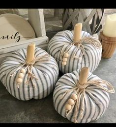 three striped pumpkins sitting on top of a table next to a candle and other decorations