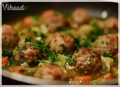 meatballs and vegetables are being cooked in a pan