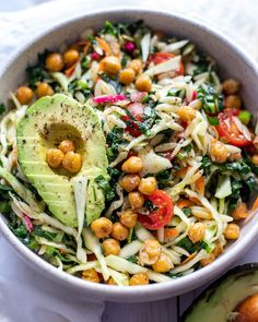 a white bowl filled with salad and an avocado