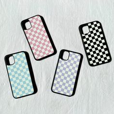 three iphone cases sitting next to each other on a white surface with checkered pattern