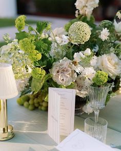 the table is set with white and green flowers