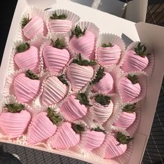 a box filled with pink and white chocolate covered strawberries on top of a table