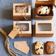 four boxes with different types of pastries on top of a blue cloth covered table