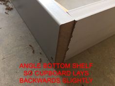 the bottom half of an empty shelf is shown with text overlay that reads angle bottom shelf so cupboard lays backwards slightly