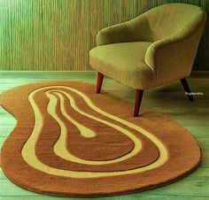 a chair sitting on top of a wooden floor next to a rug with an abstract design