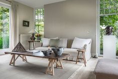 a living room filled with furniture and lots of window sill space next to a couch