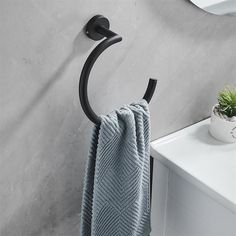 a towel hanging on the side of a wall next to a potted plant and mirror