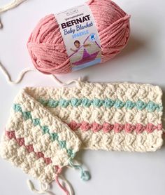 two crocheted mitts and a ball of yarn