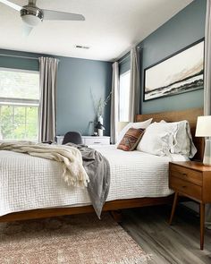 a bedroom with blue walls and white bedding