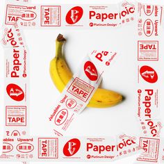 a banana is taped to the side of a piece of paper with red and white stickers on it