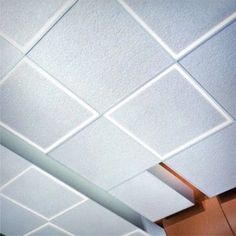 the ceiling in an office building is white and has square shaped tiles on it's surface