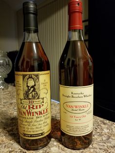 two bottles of wine sitting on top of a counter