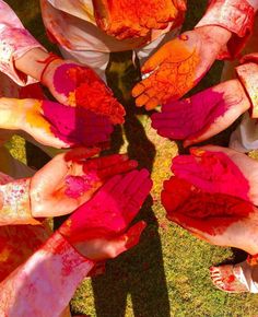 several people with their hands covered in red and yellow paint