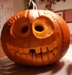 a carved pumpkin with two holes in it's face and eyes, on a table