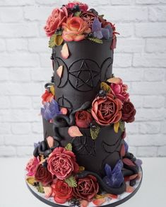 a three tiered cake decorated with flowers and leaves