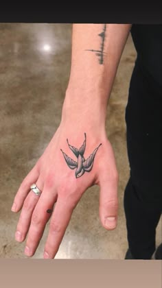 a person's hand with a bird tattoo on it