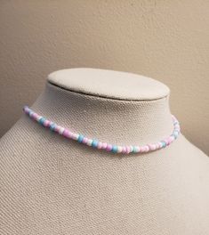 This beaded choker features matte finish beads.  The beads are pastels of blue, purple, pink, and white.  The order is random and each necklace will be of a different pattern.  The beaded portion is 14 in long with a 2 adjustable chain. Adjustable Purple Choker With Colorful Beads, Pastel Beaded Necklaces With Round Beads, Adjustable Pink Colorful Beaded Choker, Adjustable Pink Beaded Choker, Adjustable Pink Choker With Colorful Beads, Adjustable Pastel Beaded Necklaces, Pink Adjustable Beaded Chain Choker, Adjustable Pink Beaded Chain Choker, Trendy Pink Beaded Choker