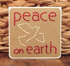 a sign that says peace on earth in red and white letters next to a woven basket