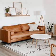 a brown leather couch sitting on top of a white rug