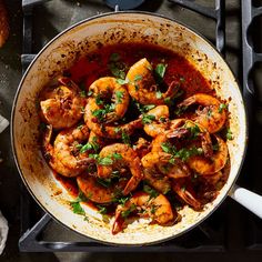 a pan filled with cooked shrimp on top of a stove