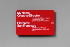 a red business card sitting on top of a gray table next to a white wall