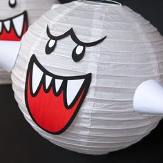 two paper lanterns with faces and mouths on them