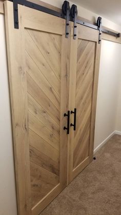 two wooden doors with black hardware are open in the corner of a room that has carpeted flooring and white walls