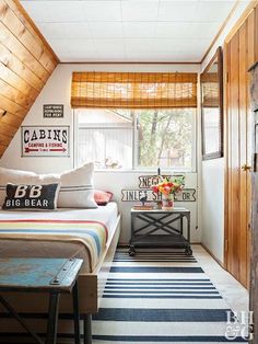 a bedroom with striped rugs and wooden walls