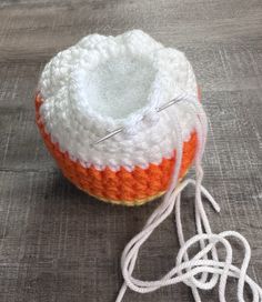 an orange and white crochet ball sitting on top of a wooden floor