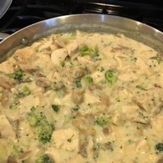 a pan filled with chicken and broccoli on top of a stove