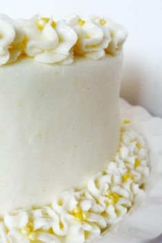 a cake with white frosting and yellow sprinkles sitting on a plate