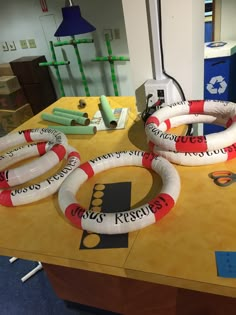 three life preservers sitting on top of a table next to a lamp and other items