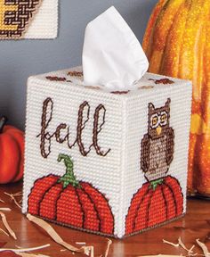 a tissue box with an owl and pumpkin design on it sitting next to some pumpkins